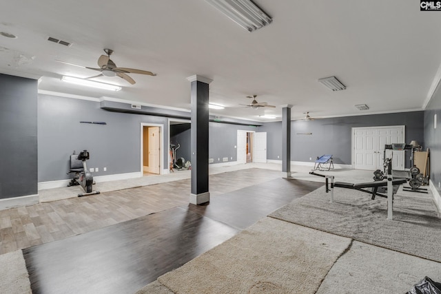 interior space with crown molding, visible vents, and wood finished floors