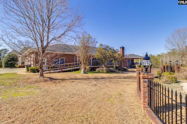 single story home featuring a chimney, a front yard, fence, and brick siding