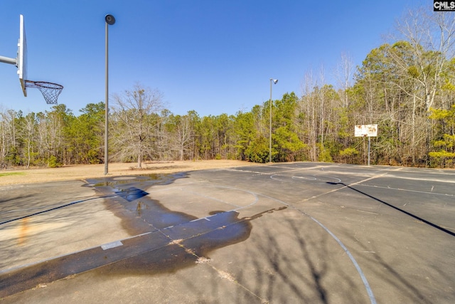 view of sport court featuring community basketball court and a view of trees