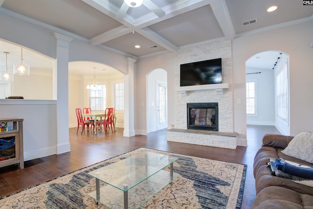 living room featuring beam ceiling, coffered ceiling, a fireplace, and wood finished floors