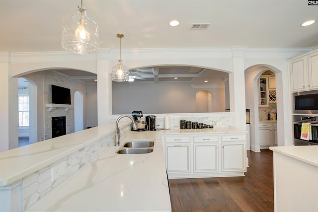 kitchen featuring a sink, visible vents, appliances with stainless steel finishes, backsplash, and light stone countertops