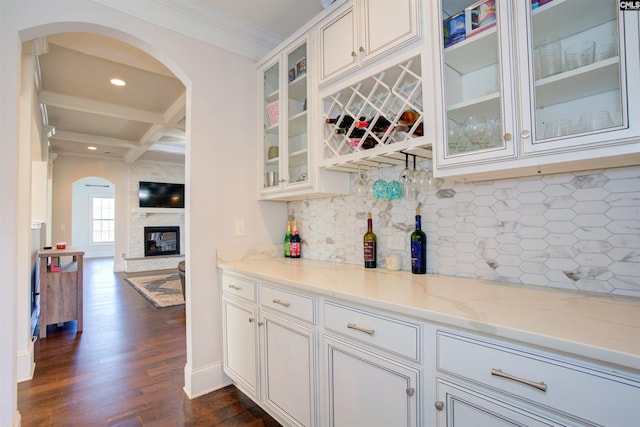 bar with coffered ceiling, dark wood-style floors, ornamental molding, beamed ceiling, and backsplash