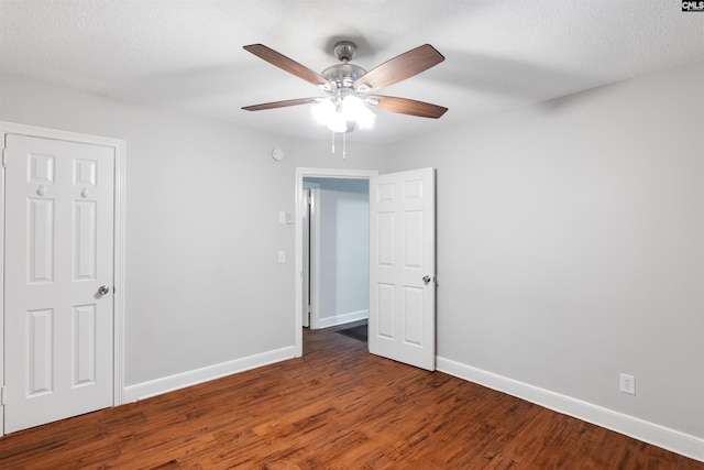 interior space with a textured ceiling, wood finished floors, a ceiling fan, and baseboards