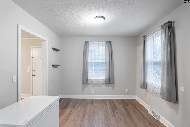 interior space featuring visible vents, wood finished floors, a wealth of natural light, and baseboards