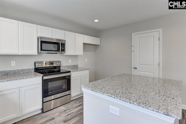 kitchen featuring appliances with stainless steel finishes, light stone countertops, and white cabinets