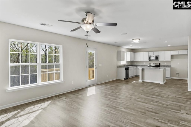 unfurnished living room featuring ceiling fan, recessed lighting, visible vents, light wood-style floors, and baseboards