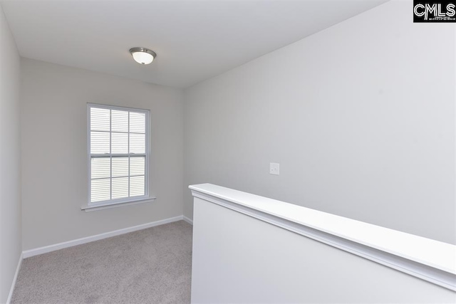 carpeted empty room featuring baseboards