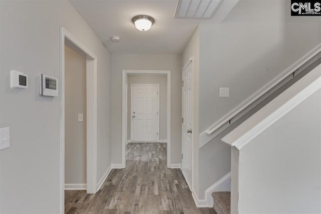 corridor with visible vents, stairway, baseboards, and wood finished floors