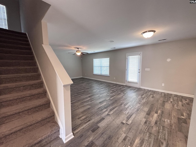 interior space with baseboards, visible vents, a ceiling fan, dark wood-style floors, and stairs