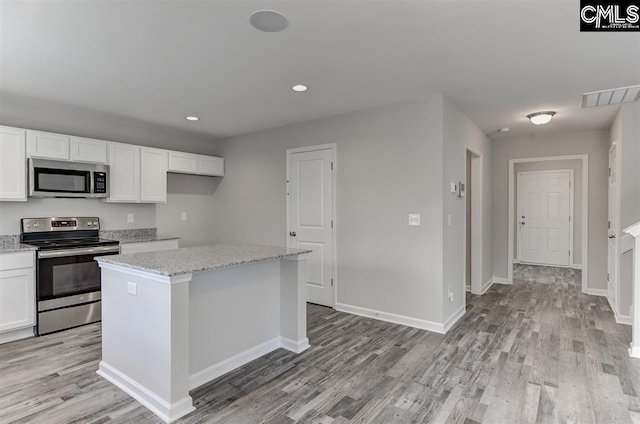 kitchen featuring appliances with stainless steel finishes, light wood-type flooring, white cabinetry, and visible vents