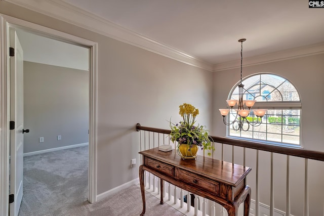 interior space featuring ornamental molding, a chandelier, carpet flooring, and baseboards