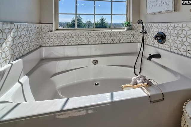 bathroom with a healthy amount of sunlight and a tub to relax in