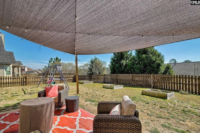 view of patio / terrace with a playground, a fenced backyard, and a vegetable garden