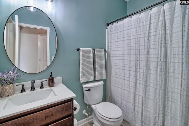 bathroom with a shower with curtain, vanity, toilet, and baseboards