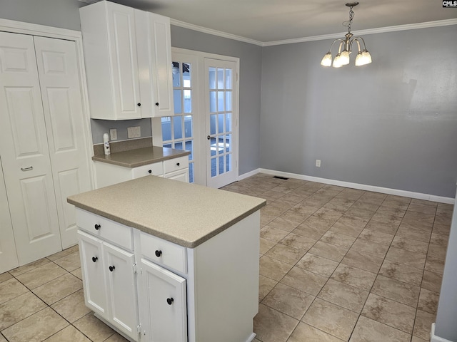 kitchen featuring a notable chandelier, crown molding, light tile patterned floors, hanging light fixtures, and white cabinetry