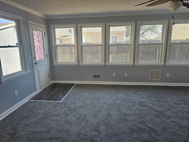 unfurnished sunroom featuring ceiling fan, visible vents, and a healthy amount of sunlight