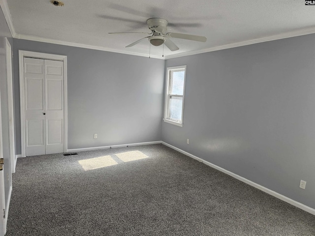 unfurnished bedroom featuring baseboards, a textured ceiling, ornamental molding, and carpet flooring