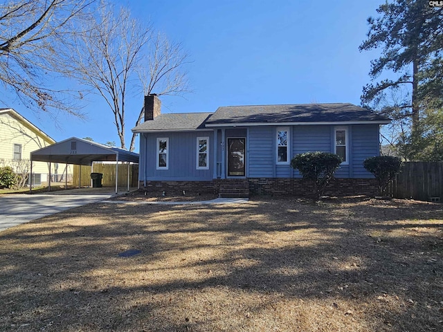 view of front of home featuring concrete driveway, a chimney, fence, and a detached carport