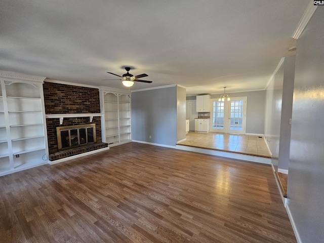 unfurnished living room with crown molding, a fireplace, baseboards, and wood finished floors