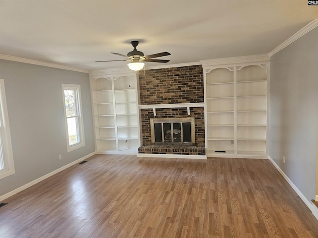 unfurnished living room featuring baseboards, crown molding, and wood finished floors