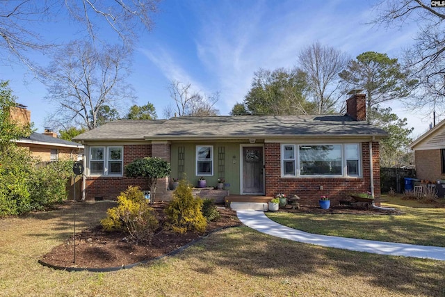 view of front of property with brick siding, a chimney, and a front lawn