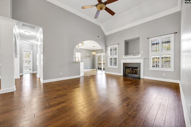 unfurnished living room featuring ceiling fan with notable chandelier, wood finished floors, a fireplace with flush hearth, visible vents, and ornamental molding