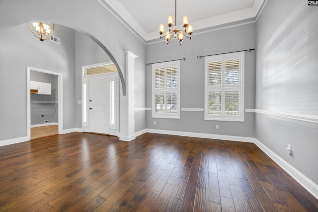 foyer entrance with wood finished floors, visible vents, baseboards, ornamental molding, and an inviting chandelier