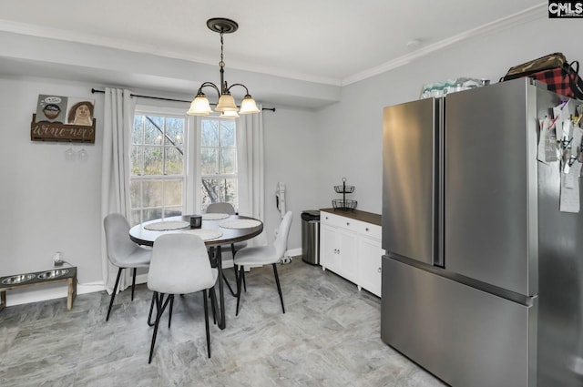 dining space with ornamental molding, a notable chandelier, and baseboards