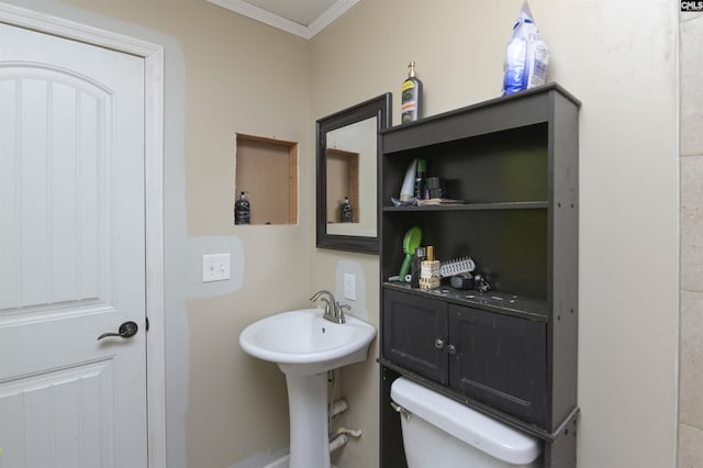 bathroom featuring crown molding and toilet