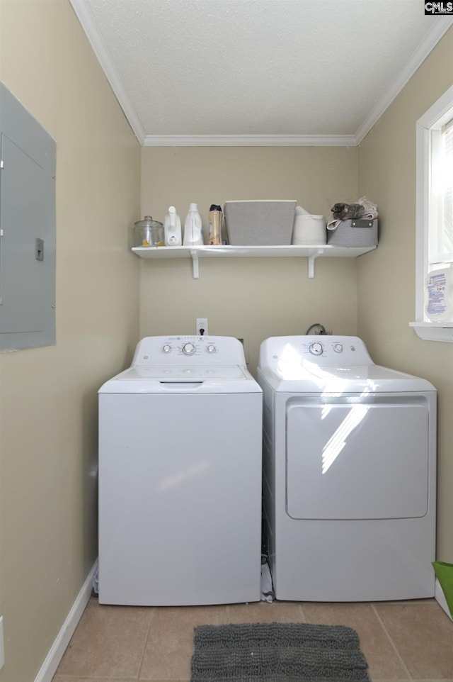 clothes washing area featuring laundry area, light tile patterned floors, electric panel, washer and clothes dryer, and crown molding