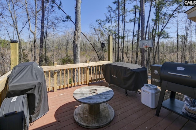 deck featuring a forest view and area for grilling