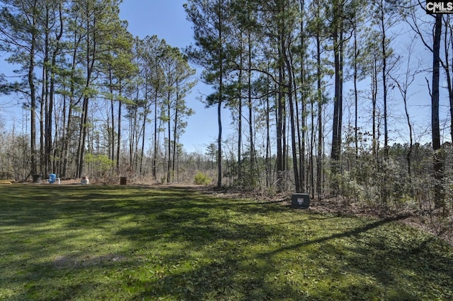 view of yard with a view of trees