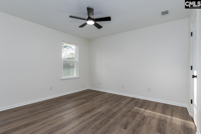 empty room with dark wood-style flooring, visible vents, ceiling fan, and baseboards