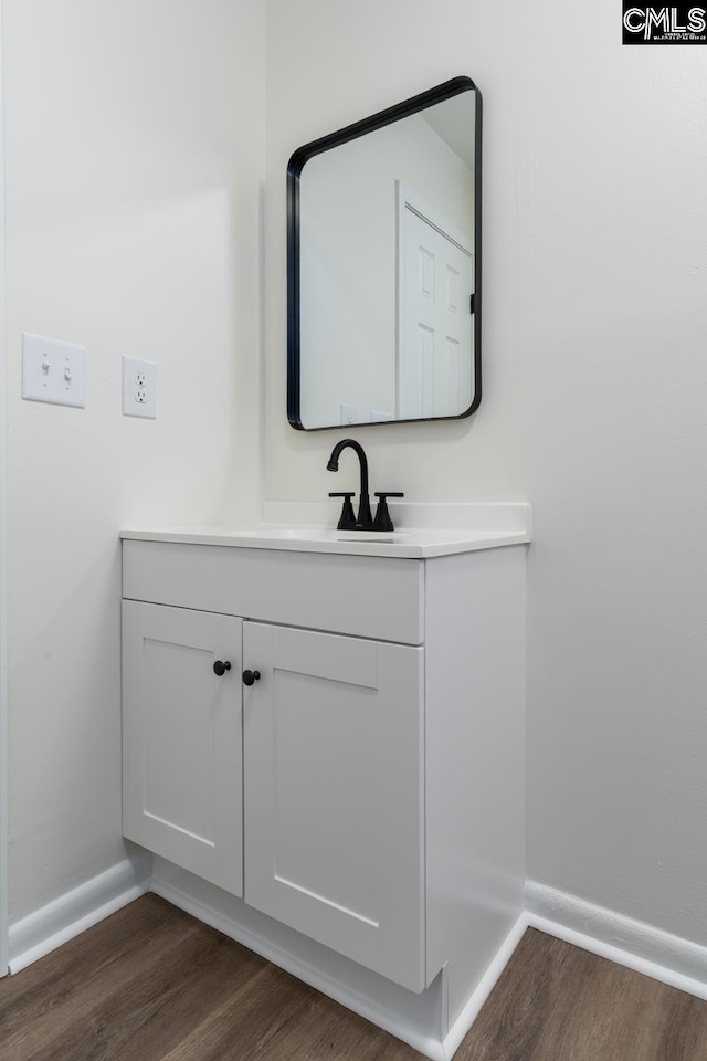 bathroom featuring wood finished floors, vanity, and baseboards