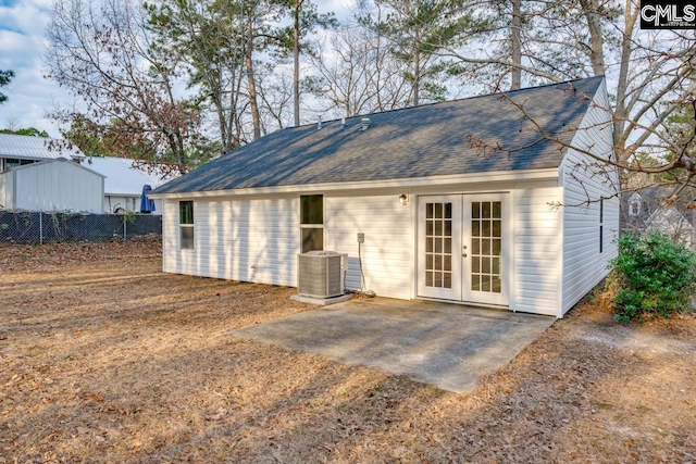 view of outbuilding featuring central AC unit, fence, and french doors