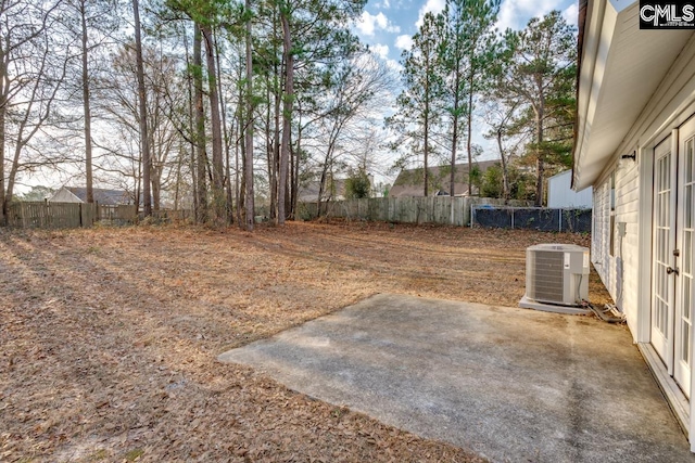 view of yard with a patio area, a fenced backyard, and central AC unit