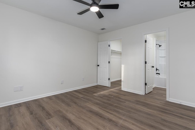 unfurnished bedroom with dark wood-type flooring, visible vents, and baseboards