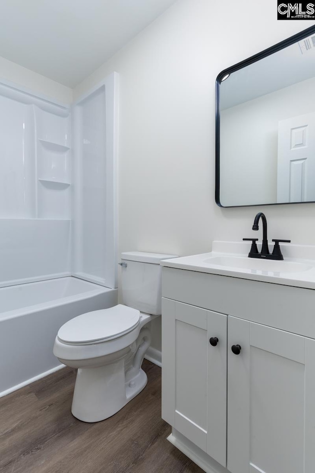 bathroom featuring vanity, shower / bathing tub combination, wood finished floors, and toilet