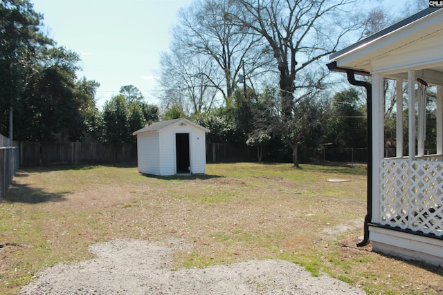 view of yard with an outbuilding, a fenced backyard, and a storage shed