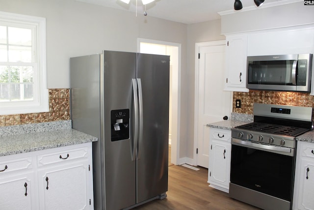 kitchen featuring stainless steel appliances, dark wood-style flooring, white cabinetry, and tasteful backsplash