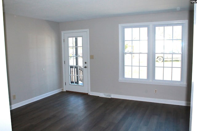 entryway with baseboards, visible vents, and dark wood finished floors