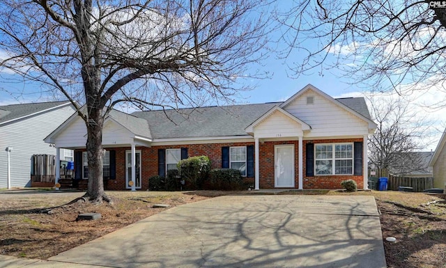 view of front of property featuring a shingled roof, a porch, and brick siding