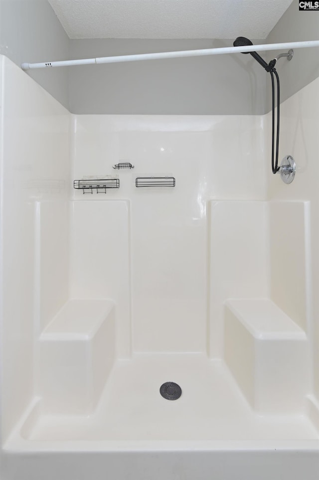 bathroom with a textured ceiling and walk in shower