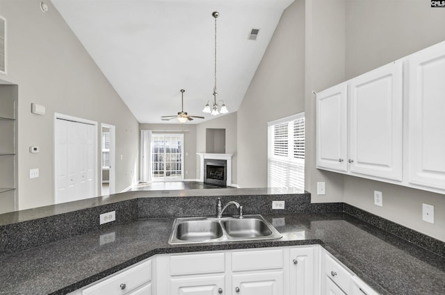 kitchen featuring visible vents, open floor plan, a sink, a wealth of natural light, and ceiling fan with notable chandelier