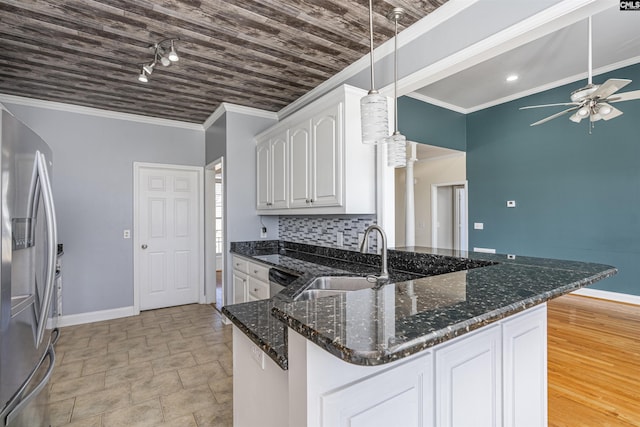 kitchen with stainless steel appliances, a sink, white cabinetry, ornamental molding, and dark stone counters