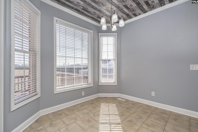 empty room featuring baseboards, an inviting chandelier, visible vents, and crown molding