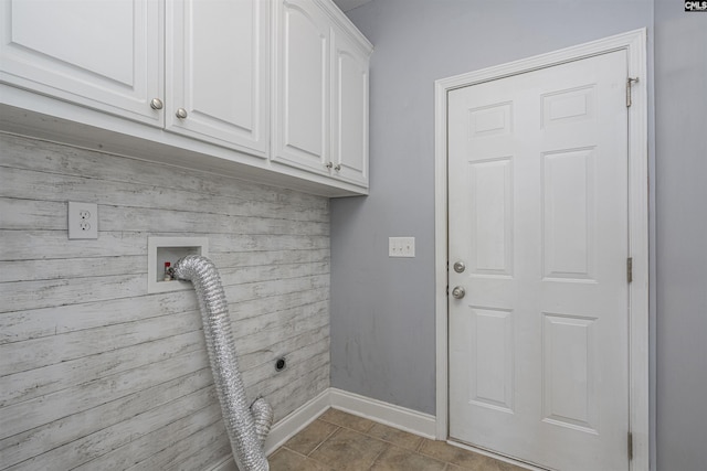 washroom featuring cabinet space, baseboards, hookup for a washing machine, tile patterned flooring, and wood walls