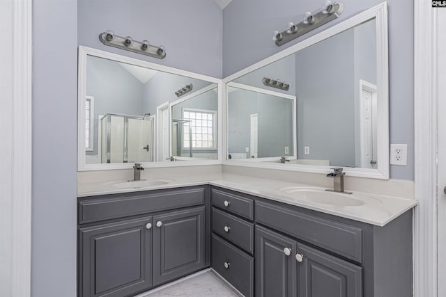 full bath featuring vaulted ceiling, double vanity, a stall shower, and a sink