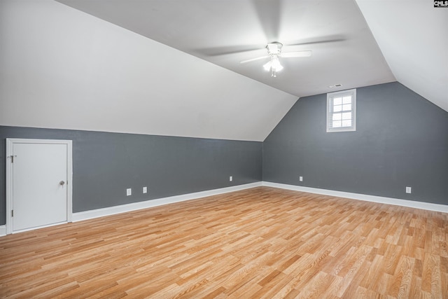 bonus room with vaulted ceiling, ceiling fan, light wood finished floors, and baseboards