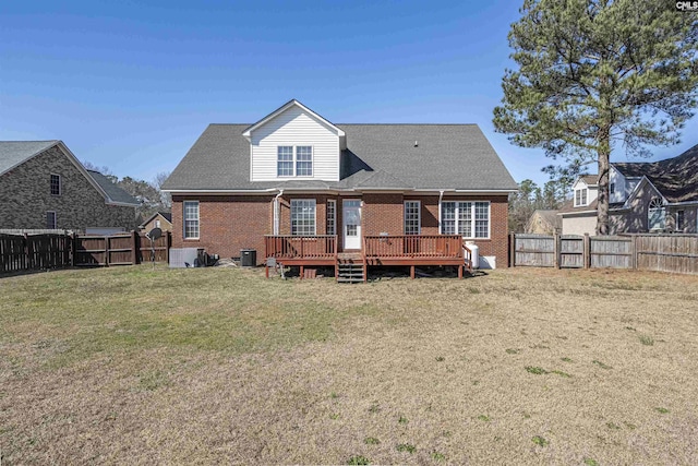 back of house featuring brick siding, a lawn, a fenced backyard, and a wooden deck